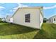 Exterior of home featuring a window, white siding, green lawn, and nearby homes in a residential area at 1112 Carvello Dr, The Villages, FL 32162