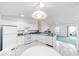 Well-lit kitchen with white appliances, a breakfast bar, and a view into the living room at 1112 Carvello Dr, The Villages, FL 32162