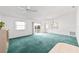 Open-concept living room with a ceiling fan, carpeted flooring, and natural light at 1112 Carvello Dr, The Villages, FL 32162