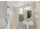 Bright bathroom with a walk-in shower, pedestal sink, and modern fixtures at 114 Ne 11Th Ave, Ocala, FL 34470