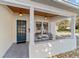 Inviting front porch with teal door and metal chairs at 114 Ne 11Th Ave, Ocala, FL 34470