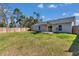 Expansive backyard with a wooden deck under a sun shade, offering a relaxing outdoor living space with a secure fence at 13787 Sw 43Rd Cir, Ocala, FL 34473