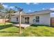 Exterior rear view with covered wood deck, lush lawn, and sliding doors enhancing the outdoor living experience at 13787 Sw 43Rd Cir, Ocala, FL 34473