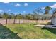 Large, fenced backyard featuring a wood deck under a sun shade provides ample space for outdoor activities and entertaining at 13787 Sw 43Rd Cir, Ocala, FL 34473