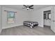 This bedroom has grey floors, a large window and a ceiling fan at 13787 Sw 43Rd Cir, Ocala, FL 34473