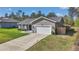 Traditional home featuring a 1-car garage, concrete driveway, and a manicured lawn at 13787 Sw 43Rd Cir, Ocala, FL 34473