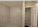 Bathroom shower features tiled walls and a modern shower head, and a closet with shelving at 14259 Se 33Rd Ter, Summerfield, FL 34491