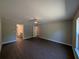 Bedroom with wood-look floors, a ceiling fan and doors to an en-suite bathroom at 14259 Se 33Rd Ter, Summerfield, FL 34491