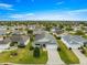 A panoramic aerial view of a well-maintained neighborhood with lush green lawns and a clear blue sky at 2418 Hopespring Loop, The Villages, FL 32162