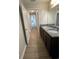Hallway view of a modern bathroom featuring dual sinks with granite countertops and dark cabinetry at 2792 Sw 161St Loop, Ocala, FL 34473