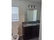 Bathroom with a dual sink vanity, ample lighting, and a view of the adjacent toilet area at 2792 Sw 161St Loop, Ocala, FL 34473