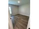 A bright bedroom featuring durable wood flooring and a clean, minimalist aesthetic with a window for natural light at 2792 Sw 161St Loop, Ocala, FL 34473