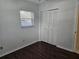 Bedroom with dark wood floors and a window with blinds at 3333 Se 12Th St, Ocala, FL 34471