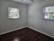 Bright bedroom with dark wood laminate flooring and dual windows at 3333 Se 12Th St, Ocala, FL 34471