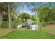 Fenced backyard with lush lawn leads to a canal waterway with mature trees at 35428 Crescent Dr, Fruitland Park, FL 34731