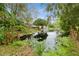 Backyard with water access featuring lush vegetation and a small boat at 35428 Crescent Dr, Fruitland Park, FL 34731