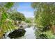 Scenic canal waterway with a dock, lush greenery, and serene reflections at 35428 Crescent Dr, Fruitland Park, FL 34731