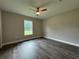 Bedroom with ceiling fan and window, wood-look floors at 3957 Se 137Th Ln, Summerfield, FL 34491