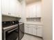 Functional laundry room with modern washer/dryer, storage cabinets, and decorative backsplash at 4721 Se 25Th Loop, Ocala, FL 34480