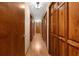 Long hallway with rich wood flooring and doors at 5000 Se 11Th Ave, Ocala, FL 34480