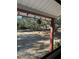 View of backyard from covered porch with string lights and lush landscaping at 5625 Sw 181St Ct, Dunnellon, FL 34432