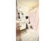 Bathroom featuring a vanity, toilet, and shower with a pink curtain; light tile floors at 5625 Sw 181St Ct, Dunnellon, FL 34432