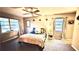 Bright main bedroom with large windows, ceiling fan, and neutral decor for a relaxing retreat at 5625 Sw 181St Ct, Dunnellon, FL 34432