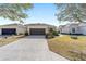 Front view of a single-story house with a two-car garage and well-manicured lawn at 6716 Sw 91St Cir, Ocala, FL 34481