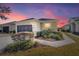 Evening view of a single-story house with a two-car garage and landscaped walkway at 6716 Sw 91St Cir, Ocala, FL 34481