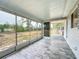 Spacious screened porch with gray tile flooring and backyard view at 7567 Sw 108Th Pl, Ocala, FL 34476