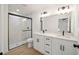 This bathroom has a double sink vanity, white cabinets, and tiled shower at 7747 Sw 146Th Lane Rd, Ocala, FL 34473