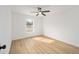 This bedroom has wood floors, white walls, and a ceiling fan at 7747 Sw 146Th Lane Rd, Ocala, FL 34473