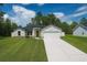 Charming single-story home featuring a well-manicured lawn, attached two-car garage, and welcoming green front door at 7747 Sw 146Th Lane Rd, Ocala, FL 34473