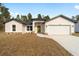 Inviting single-story home with a two-car garage, light exterior, stone accents, and a vibrant yellow-green front door at 7747 Sw 146Th Lane Rd, Ocala, FL 34473