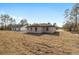 Back of house showing single-story home with a backyard and other houses at 7747 Sw 146Th Lane Rd, Ocala, FL 34473