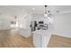 A well-lit kitchen with white cabinetry, stainless appliances, quartz countertops, and wood-look flooring at 7747 Sw 146Th Lane Rd, Ocala, FL 34473