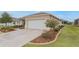 Tan house with white garage door and landscaping at 7838 Sw 85Th Cir, Ocala, FL 34481