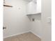 Simple laundry room with overhead cabinets and tile floor at 8217 Sw 61St Ct, Ocala, FL 34476