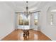 Dining area with natural light from large windows, hardwood floors, tray ceiling, and elegant chandelier at 8535 Sw 82Nd Ter, Ocala, FL 34481