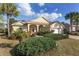 Inviting single Gathering home featuring a two-car garage, lush lawn and tropical landscaping at 8535 Sw 82Nd Ter, Ocala, FL 34481