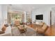 Sunlit living room with hardwood floors, neutral decor, and a seamless transition to the outdoor patio at 8535 Sw 82Nd Ter, Ocala, FL 34481