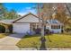 White house with a gray roof, a two-car garage, and a landscaped lawn at 8890 Sw 96Th St # D, Ocala, FL 34481