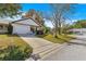 White house with a gray roof, a two-car garage, and a landscaped lawn at 8890 Sw 96Th St # D, Ocala, FL 34481