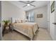 Comfortable bedroom with ceiling fan, tiled floor, and a striped comforter at 8958 Sw 57Th Place Rd, Ocala, FL 34481