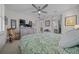 Bright bedroom with king bed, ceiling fan, dresser, and rocking chair at 8958 Sw 57Th Place Rd, Ocala, FL 34481