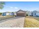 Tan house with brown garage door and brick driveway at 9119 Sw 70Th Loop, Ocala, FL 34481