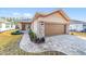 One-story house featuring a brown garage door, stone accents, and a landscaped walkway at 9119 Sw 70Th Loop, Ocala, FL 34481