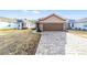 Tan house with brown garage door and brick driveway at 9119 Sw 70Th Loop, Ocala, FL 34481