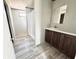 Bathroom featuring wood vanity, sink, mirror, vinyl flooring, and walk-in shower at 9160 Sw 31St Avenue Rd, Ocala, FL 34476