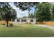 Charming tan house with white trim, a front yard with a palm tree, and wood fence at 9160 Sw 31St Avenue Rd, Ocala, FL 34476